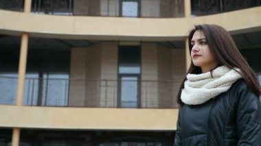Glamour girl yakın bir şehirde bir ev yavaş kışın sokak A 180 ö. pan çekim uzun bağsız kıl ile güzel bir kızın duruyor. O bir siyah anorak ve beyaz kaşkollu bir sokakta duruyor. Diye birini bekler.