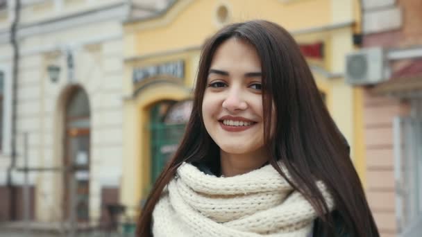 一个开朗的女孩站在城市的街道上 在冬天愉快地微笑在斯洛伐克 莫一个令人兴奋的看法 一个浪漫的女孩与深眼睛谁等待她的男朋友在街上和微笑洪瑞殷在冬天斯洛伐克 — 图库视频影像