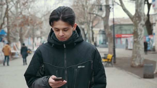 Jeune Homme Stylisé Promène Long Une Ruelle Regarde Son Téléphone — Video