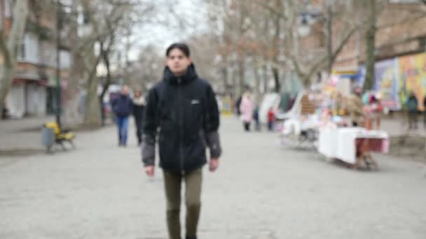 Een Jonge Man Een Zwart Parka Wandelingen Een Park Steegje — Stockvideo