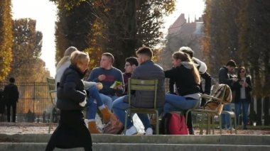 Paris, Fransa - Kasım 3, 2017:A grup öğrenci bir kafeteryada oturup ve birbirine Paris'te speak. Bir tanesi yavaş çekimde arkadaşı arayan standları.