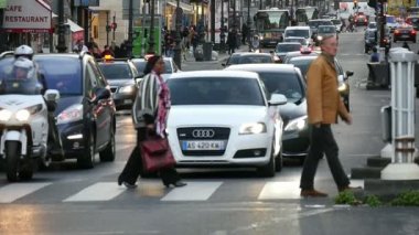 Paris, Fransa - 3 Kasım 2017: Şık insanların bir yaya geçidi ağır çekimde oluyor gösterişli bir görünüm. Bir sürü araba onlar için slo-mo Paris'te bir kesişme noktalarında bekliyor
