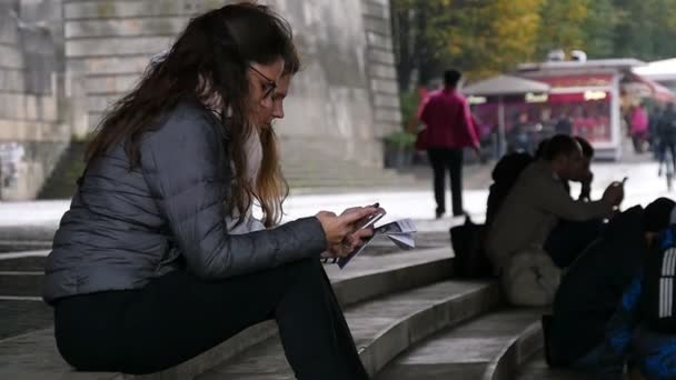日パリ フランス 2017 プロファイルをスローモーションで秋にパリのパンテオンのステップに座っているスマート フォンでスマートな女の子の表示します いくつかの材料を覚える — ストック動画