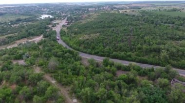 Hava güneşli bir günde Dnipro havzasında hareketli bir kamyon ile bir otoyol görüntüsünü yaz aylarında bir curvy karayolu yoğun orman ve sulak onun kıyısında ile Dnipro uzak olmayan hareketli bir kamyon ile özgün bir kuşbakışı görüntülemek
