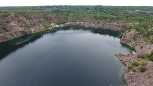 晴れた日にウクライナで砂のキャリアに小さな湖の空中ショット高銀行と美しい湖の景色は夏の晴れた日に砂 ウクライナの草で覆われています — ストック動画