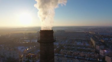 Beyaz duman Kış A kuş bakışı bir dev tüp yoğun beyaz duman Ukrayna multistoried binalarda ile kışın gün batımında soğutma batımında karlı City ile yüksek endüstriyel tüp hava atış 