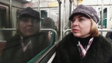 Glamour parisien sarışın Bayan metro arabaya biniyor ve şık sarışın kadın Closeup siyah kürk manto, İpek eşarp ve sonbaharda Paris'te hareketli bir metro vagonu oturan zarif şapka giymiş penceresinde görünüyor
