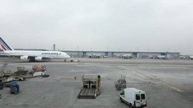 Paris, Fransa - 14 Kasım 2017: Dış hatlarda hizmet veren büyük bir beyaz uçağın heyecan verici bir manzara. Bagaj Taşıma için düşük bir forklift hareket ediyor.