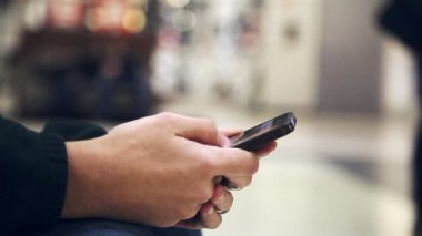 Erkek el bir smartphone tutun ve dokunmatik, ekran cam gibi bir süpermarkette bir akıllı telefon tutmak ve havadar bir alışveriş merkezinde otururken bilgi kaydırma genç adamın elleri etkileyici bir closeup