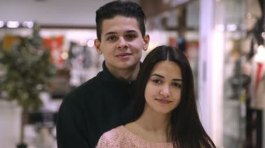 Ayakta ve birlikte modern bir süpermarkette bir genç gülümsemek gülümseyen Enarmored genç çift mutlu kız arkadaşı duran ve birlikte gülümseyen adam. Onlar aşık ve bir süpermarkette neşeli hissediyorum