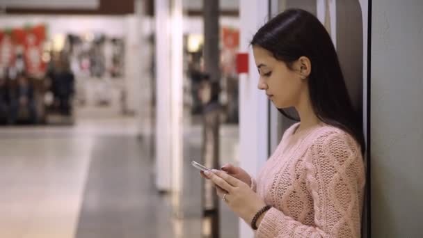 Έξυπνο Κορίτσι Στέκεται Και Κοιτάζει Smartphone Μια Υαλώδη Ψώνια Εμπορικό — Αρχείο Βίντεο