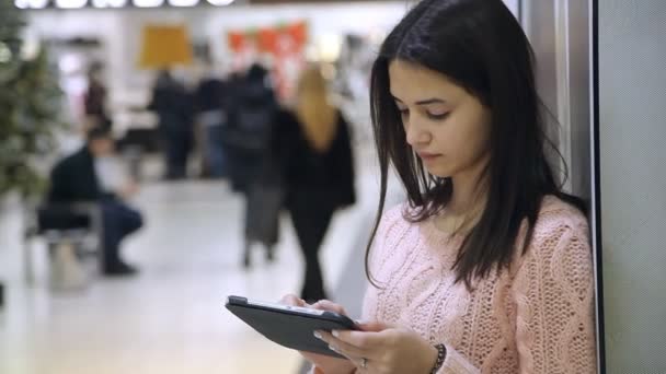 Menina Inteligente Levanta Olha Atentamente Para Seu Tablet Shopping Center — Vídeo de Stock