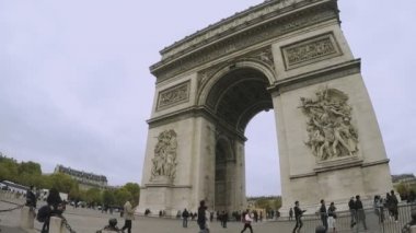 Ferforje çit ile çevrili ve turistler sonbahar yavaş çekimde yürürken Arch de Triomphe, Paris, Fransa - 8 Kasım 2017:A pitoresk görünümü. Gökyüzü gridir.
