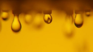Bulanık su BLOB'lar bir banyoda sarı duvarlı metalik nozzle dan yuvarlanan su damla parlayan sarı banyo A bokeh makro atış bir duş nozzle dan aşağı in. İlk damla özetlenen 