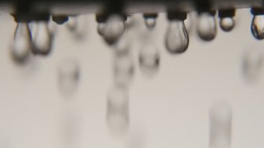 Kristal berraklığında su BLOB'ları sonbaharda parlak su mavi banyo A retro makro çekimde bir duş nozzle dan metalik duş başlığı olarak bir banyo ışık gri duvarlar ile gelen düşer 