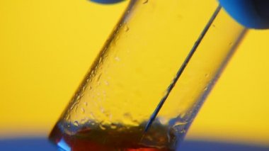 Kırmızı kan bir şırıngadan medial laboratuvarında bir şırınga bir etkileyici makro çekim bir örnek tüp içine hangi kırmızı kan içine tüp bebek sarı arka planda serpilir metalik bir iğne ile gider.