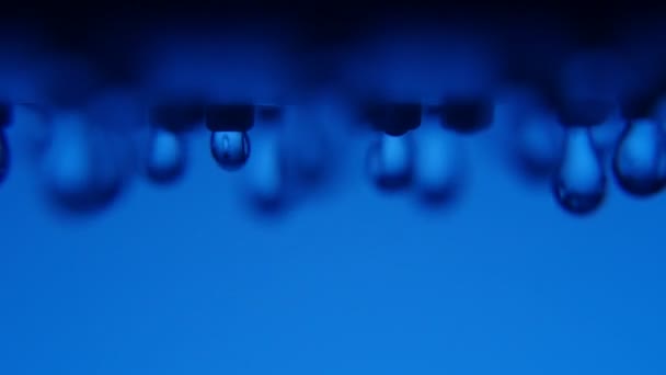 Hazzy 水塊は結晶ブルーの壁と浴室の金属ノズルから水滴の青い背景のボケ味のマクロ撮影でシャワー ノズルから降りてくる 最初の滴のとおり — ストック動画