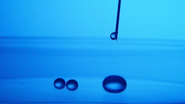 Gotas Agua Cristalina Caen Una Aguja Metálica Superficie Azul Laboratorio — Vídeos de Stock