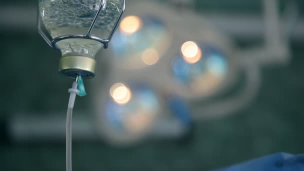 在乌克兰的一间有模糊灯的手术室里 一个透明滴柜台的软聚焦宏 带有塑料管和特殊液体 在手术背景下看到几盏灯 — 图库视频影像
