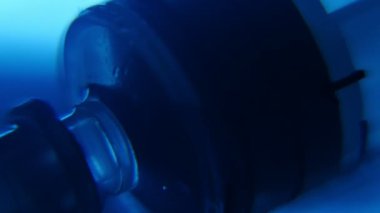 Kristal berraklığında su plastik enjektör mavi eczane laboratuvarında bir modern mavi eczane laboratuvar şeffaf su emme yatık şeffaf plastik enjektör sanatsal bir makro içinde çekilir.