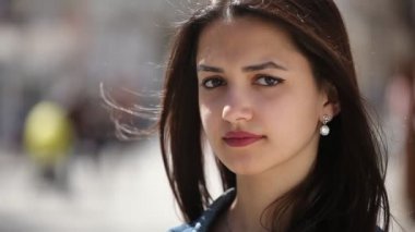 Kibar ve güzel kız gülümser bahar duran ve biraz bahar güneşli bir günde bir şehir sokakta gülümseyen uzun bağsız kıl ile güzel ve asil görünümlü kız portresi rüzgarlı havalarda sokakta