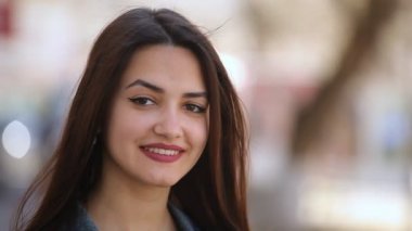Çekici genç kadın neşeyle güneşli bir günde bahar portre gülen mutlu bir arka sokakta güneşli bir günde baharda güzel bir genç kadının uzun bağsız kıl ile güzel bir sokakta güler