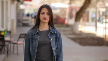 Neşeli genç kadın gülüyor mutlu bir şekilde sokakta bir şehir güneşli bir bahar gülen içtenlikle bir arka sokakta güneşli bir günde baharda mutlu olan bir genç kadın bir dayanılmaz gülümseme ve uzun bağsız kıl portresi