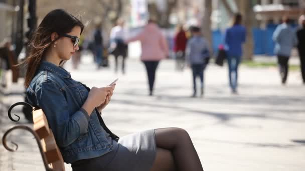 Стильная Женщина Просматривает Сеть Своем Смартфоне Сидя Скамейке Запасных Переулке — стоковое видео