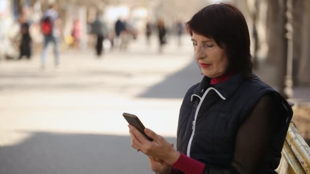 Uma Mulher Esbelta Navegando Rede Seu Smartphone Senta Banco Primavera — Vídeo de Stock