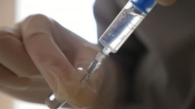 Bazı tıbbi sıvı cam ampul bir hastane odasında elleri bir şırınga tutarak etkileyici bir manzara ve ilaç ile bir ampul şırınga berbat. Yavaş yavaş sıvı bir odada çarpık yerleştirilen suringe doldurur