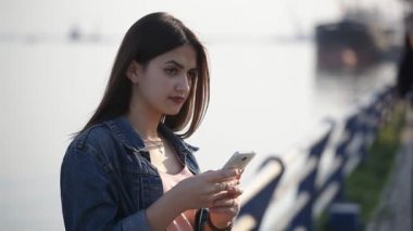Romantik kız Dnipro, Küpeşte, anlamına gelir ve net bahar güzel bir kızın profil Küpeşte Dnipro iskele üzerinde ayakta ve baharda sörf için ekranın dokunmadan uzun bağsız kıl ile göz atan