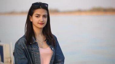 Güzel kız Dnipro ve gülümsüyor neşeyle bahar yavaş çekimde bir görünümünü Dnipro nehir kıyısındaki duran güzel ve neşeli bir genç kadın duruyor. O gülümsüyor ve bahar yavaş çekimde iyi hissettiriyor