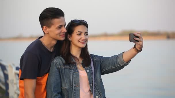 Szczęśliwa Dziewczyna Bierze Sobie Selfie Jej Mężczyzna Całuje Jej Policzek — Wideo stockowe