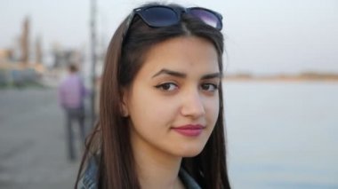 Sevdalı kız görünüyor ve Dnipro bahar Dnipro dolgu üzerinde duran hoş bir genç kadın portresi slo-mo içinde gülümseyen duruyor. O güzel gözlerinin içine bahar slo-mo parıldıyor ile gülümsüyor.