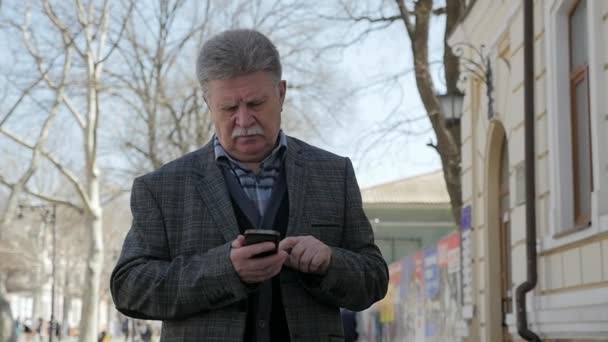 Сіроголові Чоловік Вусами Ходить Переглядає Мережу Телефону Навесні Шлю Портрет — стокове відео