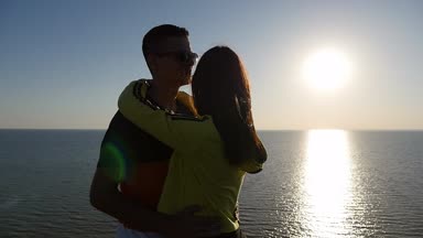 Sevdalı çift romantik bir gün batımında Karadeniz sahilinde yaz profil tutkulu genç bir adam onun mutlu sevgilim, Karadeniz yavaş çekimde bir altın güneş yolu ile muhteşem bir günbatımı, sarılma hugs