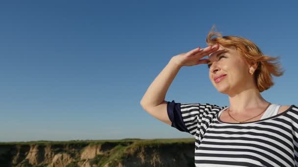 Donna Bionda Tiene Mano Sugli Occhi Sulla Riva Del Mar — Video Stock