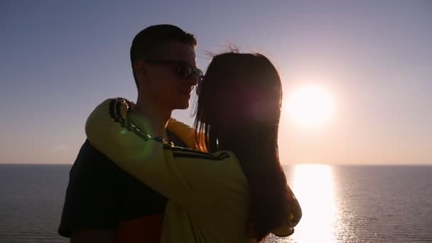 浪漫的一对拥抱在一个梦幻般的日落在黑海海岸在夏季剖面的一个充满激情的人拥抱他纤细的甜心在风景如画的日落与金色的太阳路径在黑海慢动作 — 图库视频影像