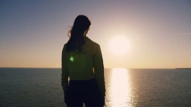 Sevdalı kız Karadeniz kıyısında duruyor ve altın Günbatımında geri bir kadının aşk Karadeniz sahilinde ayakta ve yaz aylarında güneş yolu ile batımında sevgilisi hakkında hayal uzun bağsız kıl ile görünüm