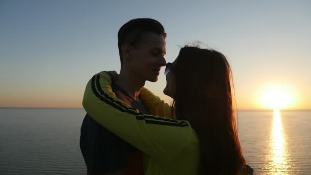 好色な女の子は 夏黒海ビーチに輝く夕暮れ時のカップルの愛の夏の夕暮れ時 黒海沿岸で彼女の幸せな少年を抱擁します サングラスの女の子は 彼女の男の首に彼女の手を保つ — ストック動画