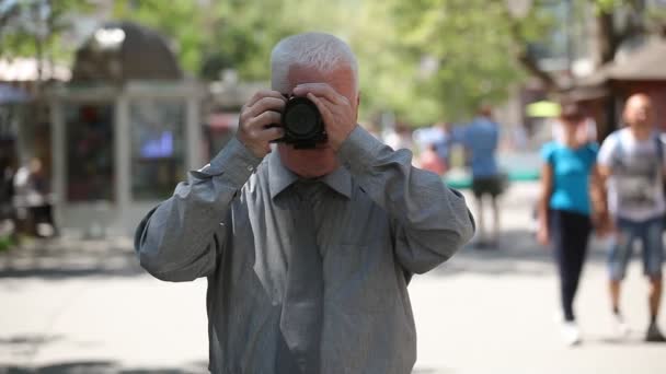 Ανώτερος Άνθρωπος Στέκεται Γυρίζει Αριστερά Και Δεξιά Παίρνει Φωτογραφίες Ένα — Αρχείο Βίντεο