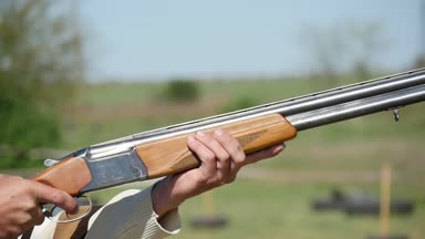 Sporcu bir skeet aralığını yazın bir avcı onun üzerinde ve altında çift namlu shortgun yükselterek ve çekimde çekim slo-mo profilde silahıyla pratiği yapıyor. Tüfek geri tepme güneşli bir günde sarsıntıları..