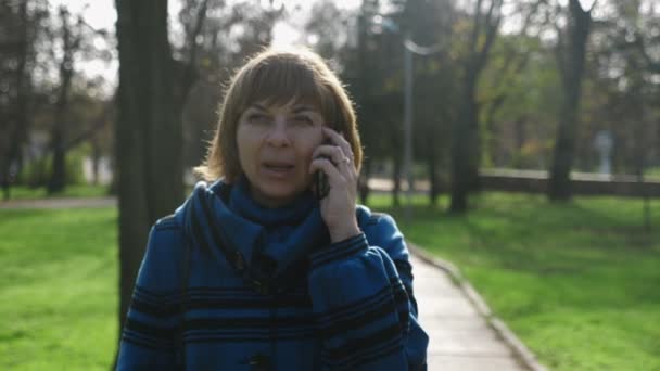 Fröhliche Blonde Frau Spaziert Und Telefoniert Einem Park Sommer Slo — Stockvideo