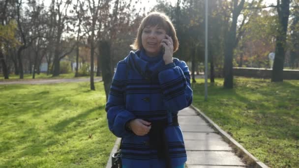 Mulher Loira Feliz Andando Falando Telefone Parque Verão Slo Vista — Vídeo de Stock