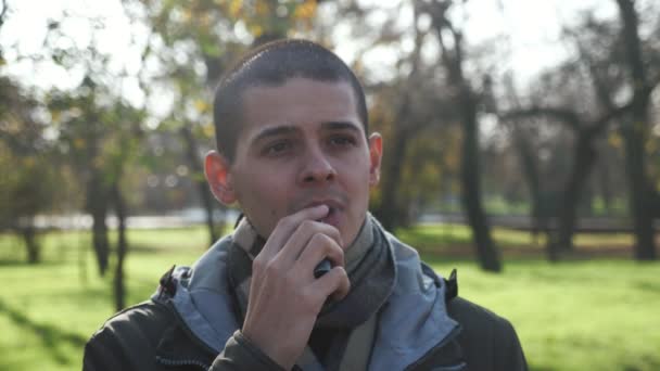 Jovem Alegre Vaping Cigarro Eletrônico Parque Outono Câmera Lenta Retrato — Vídeo de Stock