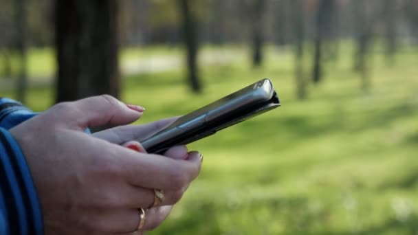 Manos Femeninas Manteniendo Teléfono Inteligente Imágenes Desplazamiento Parque Slo Impresionante — Vídeos de Stock