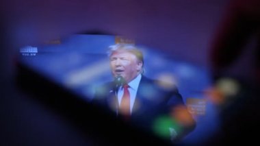 Kiev, Ukrayna - 8 Kasım 2019: Ritzy Donald Trump 'ın akıllı telefon ekranında sohbet edişinin iyimser görüntüsü. Amerikan seyircilerini ikna ediyor. Erkek eli masanın üzerine huis görüntüsü olan bir akıllı telefon koyuyor.
