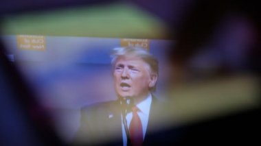 Kiev, Ukrayna - 8 Kasım 2019: Akıllı telefon ekranında konuşan mutlu Donald Trump 'ın iyimser görüşü. O, Amerikan seyircisinin önünde hayatından zevk alıyor. Erkek parmağı kaymağını yiyor.