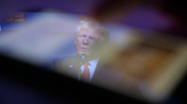 Kiev, Ukrayna - 8 Kasım 2019: akıllı telefon ekranında neşeli Donald Trump 'ın konuşması. O, Amerikan seyircisinin önünde hayatından zevk alıyor. Erkek parmak değiştirme metinleri ona empoze edildi