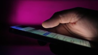 Erkek eli bir telefon ekranına mesaj ve resimlerle dokunuyor ve kaydırıyor. Bir erkeğin akıllı telefon ekranına mesaj ve fotoğraflarla dokunup kaydırdığı etkileyici bir yakın plan görüntüsü. Bazı gerekli bilgiler istiyor..